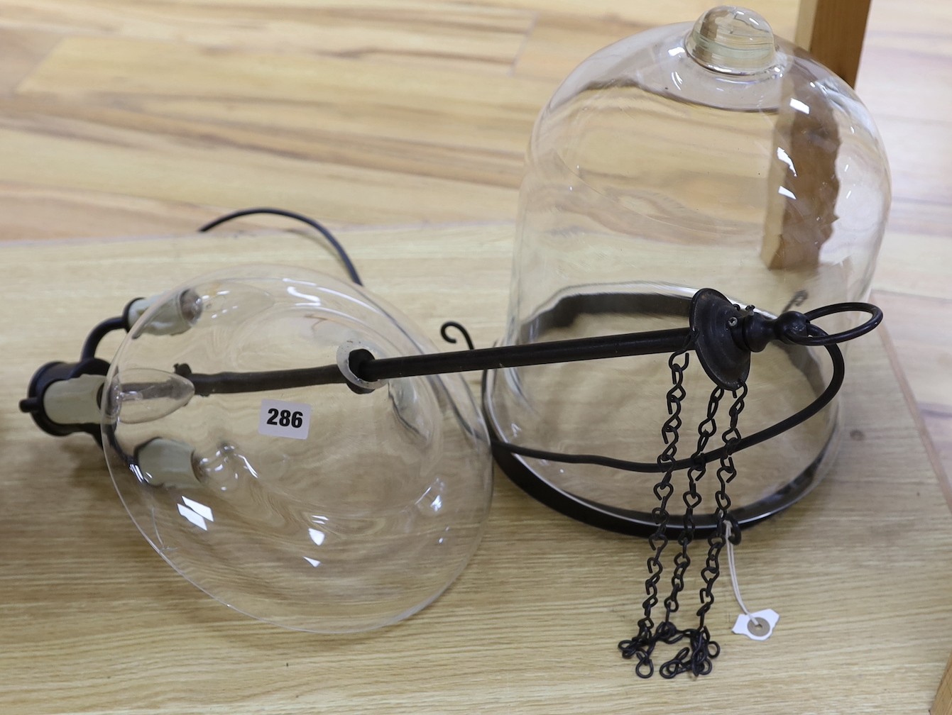 A clear glass ceiling-hanging storm lantern